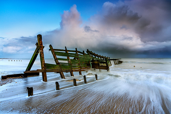 Passing storm over embattled breakwater.